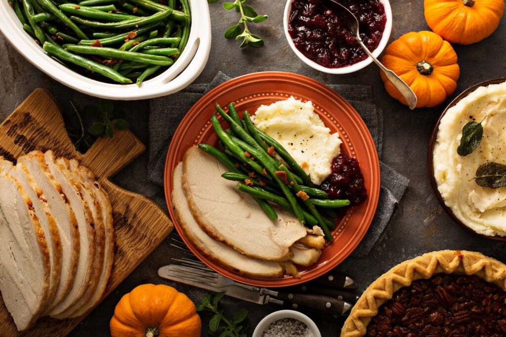 Thanksgiving foods on table with orange pumpkins